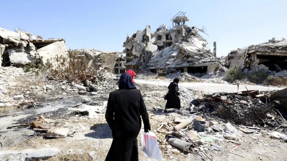 Mujeres sirias caminan por las calles destruidas de Alepo