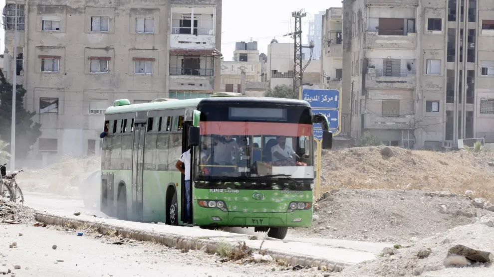 Un autobús cargado de rebeldes y familiares abandonan el bario asediado de Al Waer