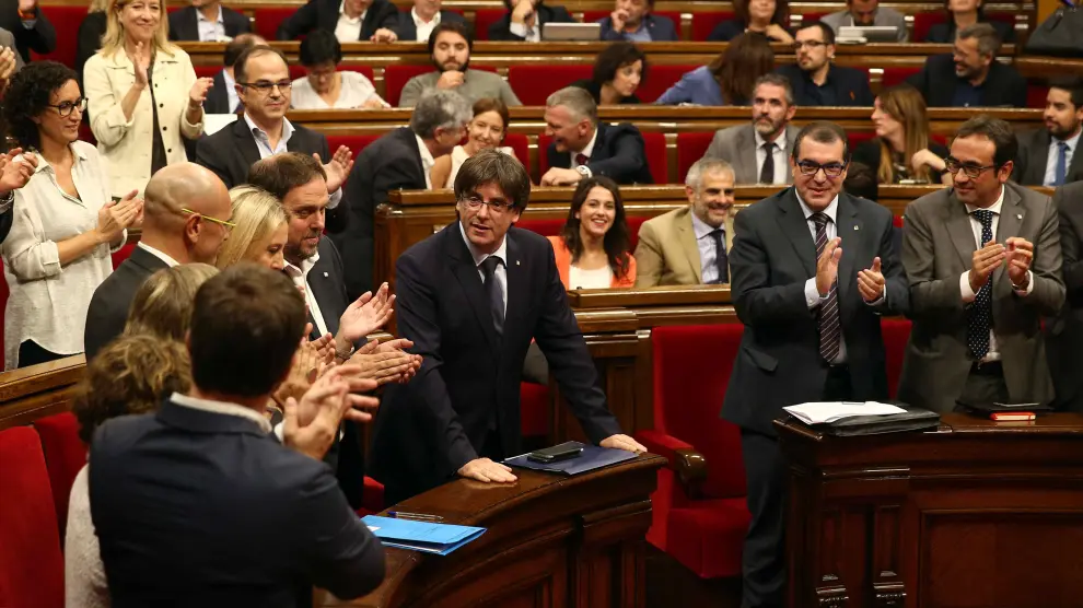 El presidente de la Generalitat, Carles Puigdemont, recibe el aplauso de sus compañeros tras su intervención en el debate de cuestión de confianza