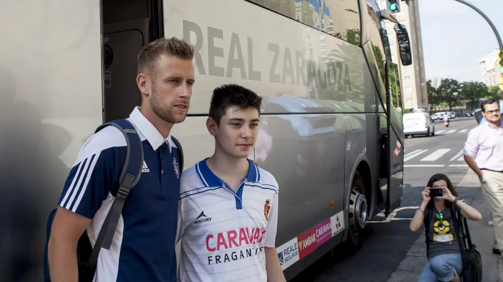 Álex Barrera se fotografía con un aficionado antes de subir al bus de camino a Valencia