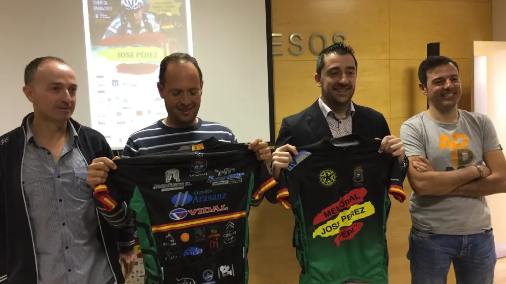 Responsables del Club Ciclista Barbastro con el concejal mostrando el mallot conmemorativo de la carrera.
