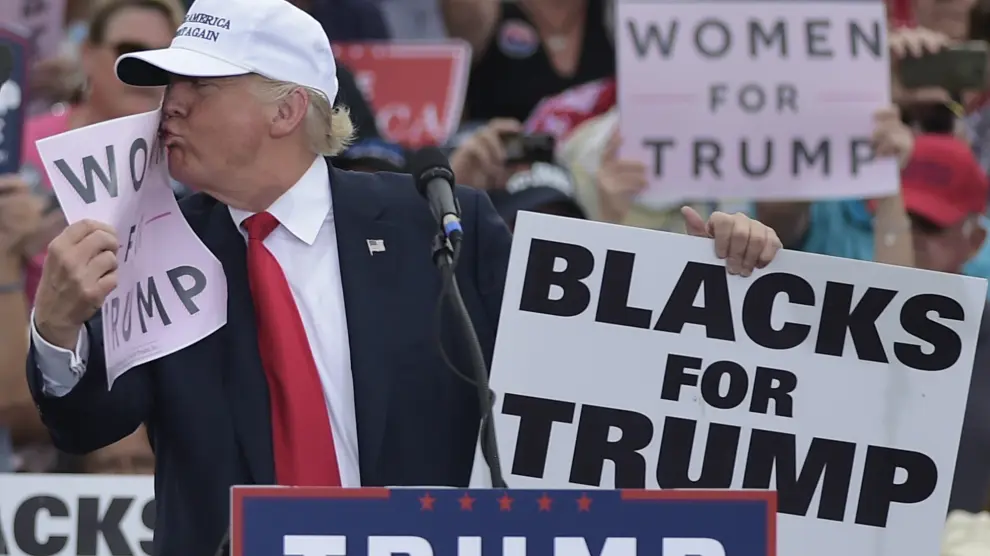 Trump besa un cartel donde nombra a las mujeres.