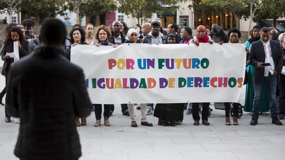 Alrededor de un centenar de personas se han concentrado este jueves por la tarde frente a la Delegación del Gobierno de Aragón para solicitar un sistema justo de acceso a la nacionalidad española por residencia