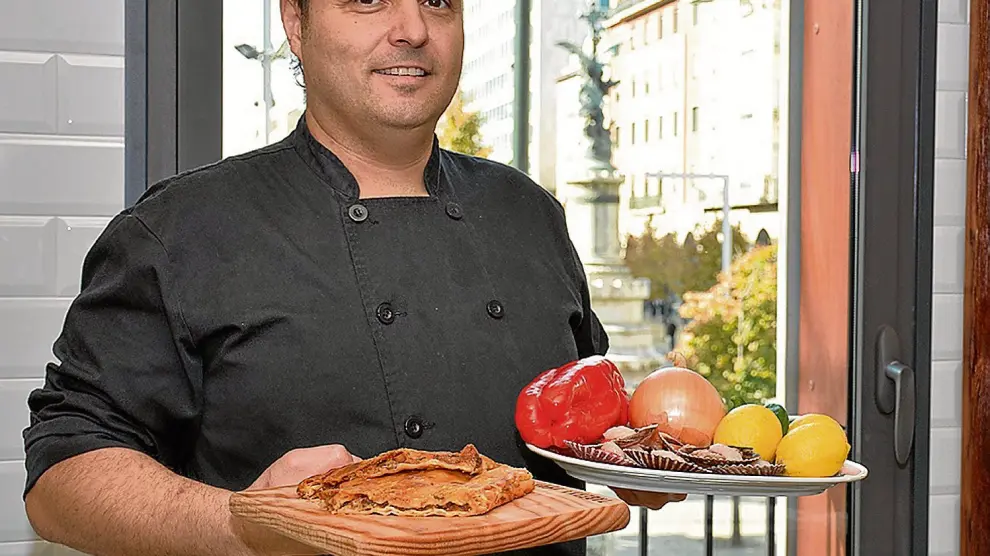José Miguel Giménez, de La Pulpería, con una empanada de zamburiñas y con los ingredientes que ha utilizado.
