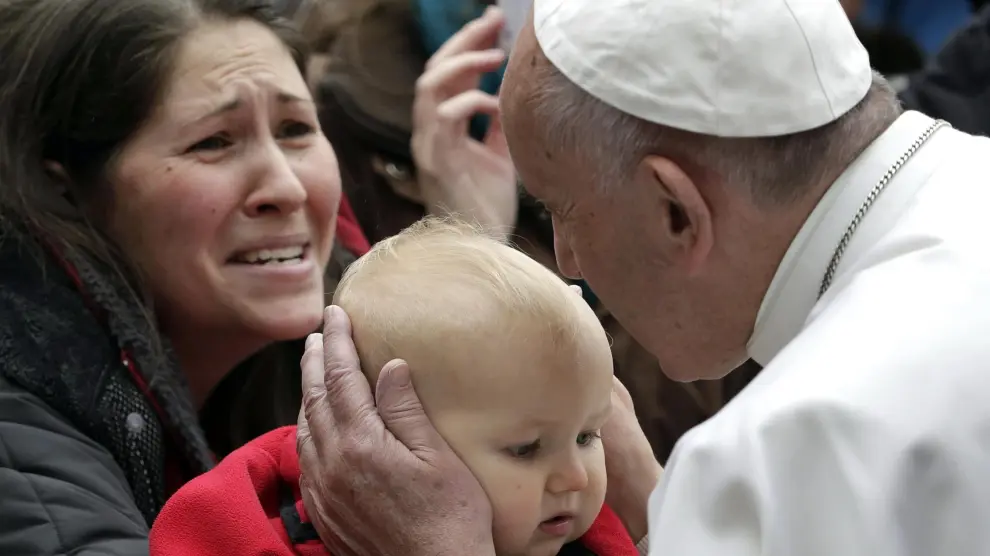 El Papa Francisco besa a un niño durante su visita a Lund, Suecia.