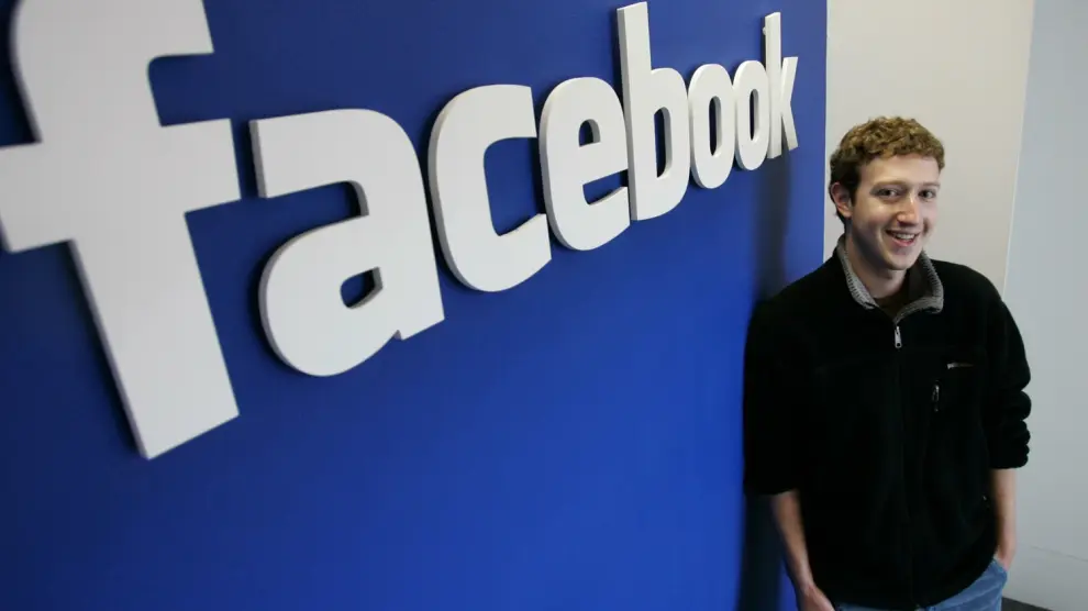 Mark Zuckerberg, ante el logo de Facebook.