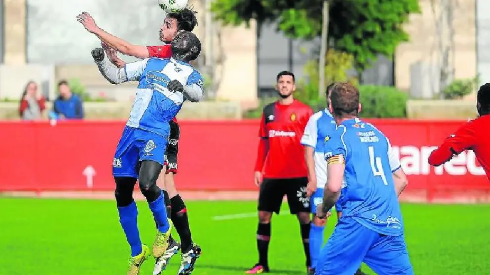 Moustapha pugna por un balón de cabeza con un futbolista del Mallorca B, ayer.