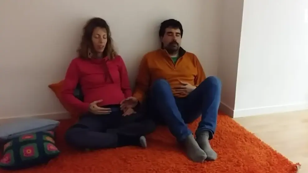 Una pareja que espera un bebé escucha música.