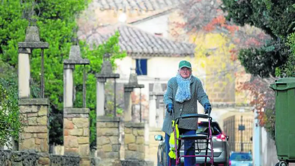 Un anciano pasea por las calles de Rubielos de Mora ayudado de un andador.