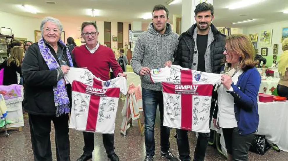 Tarde solidaria en el rastrillo de Manos Unidas. Anquela, Carlos David y Aguilera acudieron ayer por la tarde al mercadillo de Navidad que cada año organiza esta ONG en Huesca para entregar dos camisetas firmadas.