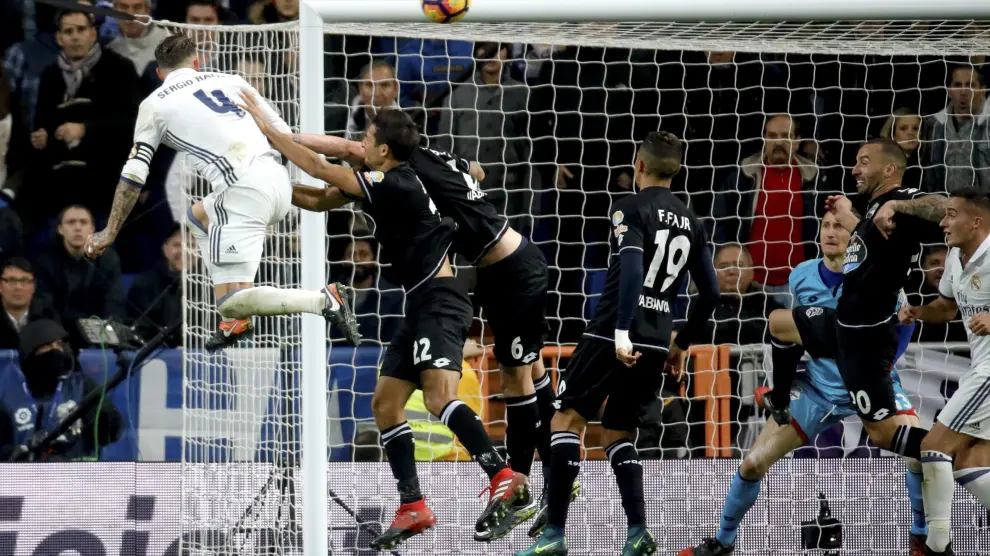 El defensa del Real Madrid Sergio Ramos (i) cabecea a puerta para conseguir el tercer gol de su equipo