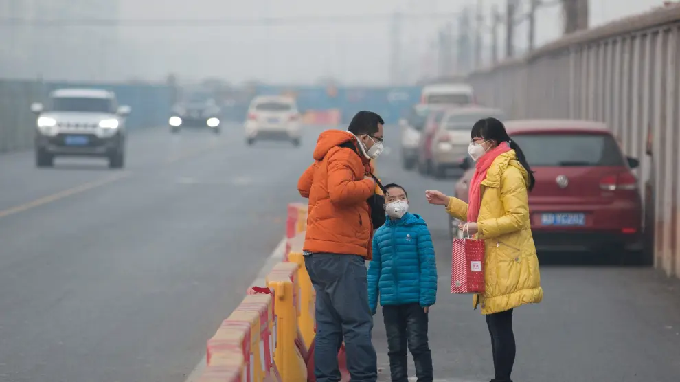 Una familia china con mascarilla por la fuerte contaminación.