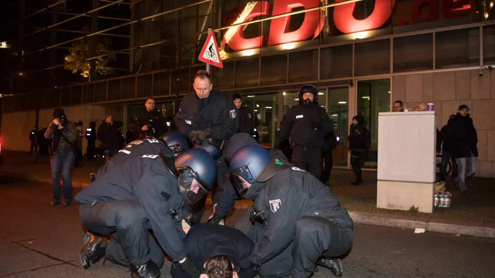 Miembros de la policía antidisturbios arrestan a un hombre durante la vigilia que extremistas de la derecha realizan hoy, miércoles 21 de diciembre de 2016, frente a la Cancillería alemana en Berlín