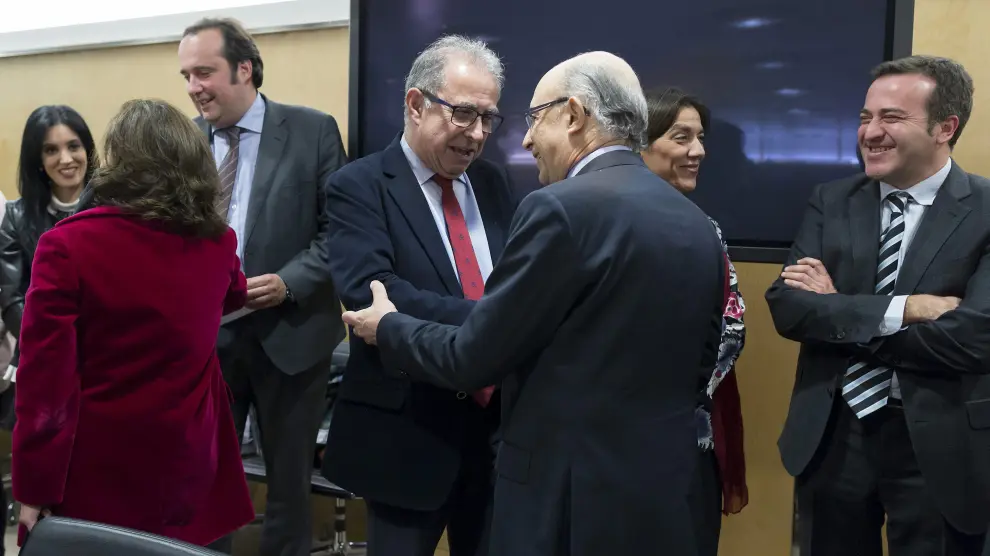En el centro, Gimeno y Montoro se saludan en el Consejo de Política Fiscal. De espaldas, la vicepresidenta Sáenz de Santamaría