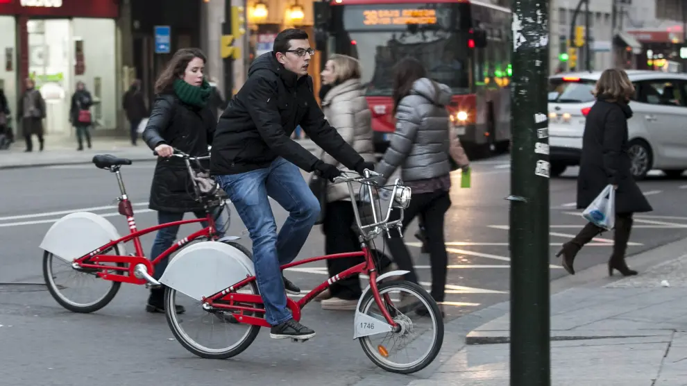 Dos usuarios del servicio público de bicicletas de alquiler Bizi, en el Coso de Zaragoza