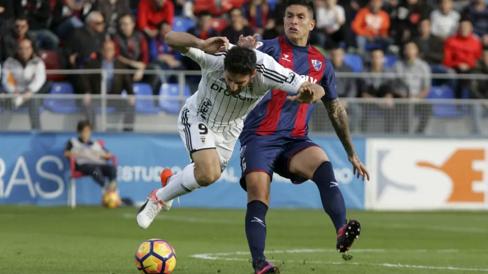 Jesús Valentín pugna una pelota con Toché, delantero del Real Oviedo.