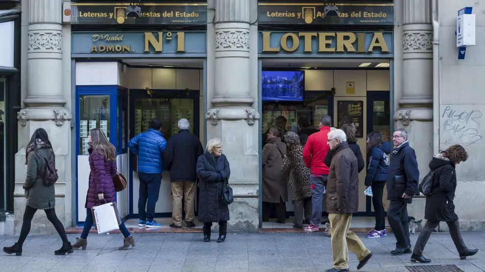 Un grupo de zaragozanos espera para comprar lotería.