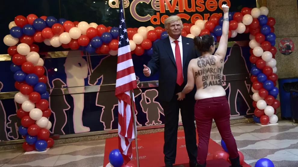 Una activista le enseña los pechos a la figura de Donald Trump en el Museo de Cera de Madrid.