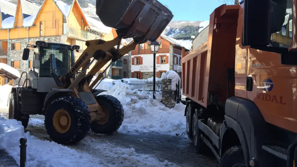 Una pala excavadora retirando este miércoles nieve con un camión en Benasque.