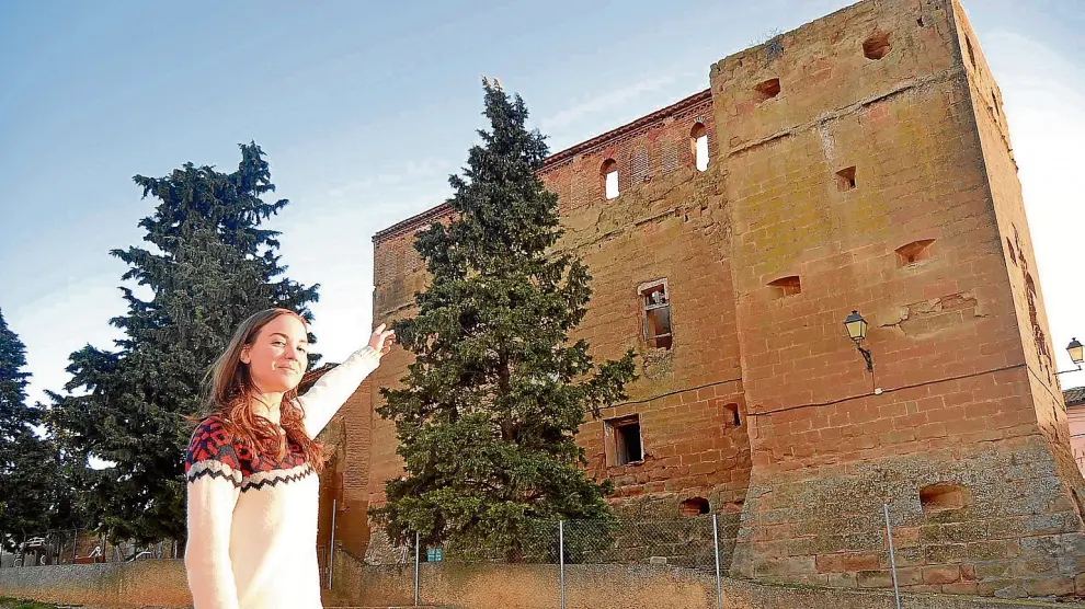 Lidia Clavero, portavoz de la asociación de vecinos de Permisán, señala el deterioro de una de las fachadas del palacio.