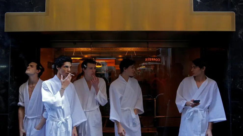 Un grupo de modelos fuma a las puertas del hotel donde se celebran los desfiles