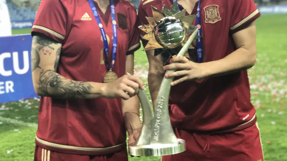 Las dos futbolistas aragonesas posan junto a la Copa Algarve.