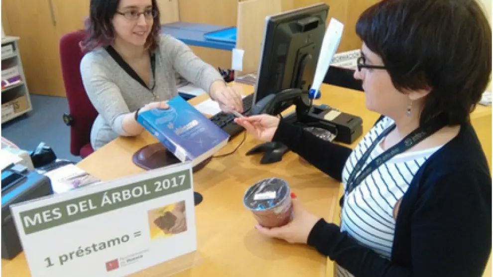 Un usuario recibe su planta en una biblioteca de Huesca