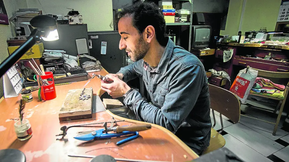 Santiago Jiménez arregla una joya en su negocio, situado en la avenida de San José.