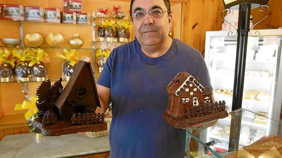 Manuel Lorés, maestro pastelero de la confitería Soler, de Huesca, con dos de las monas que vende este año.