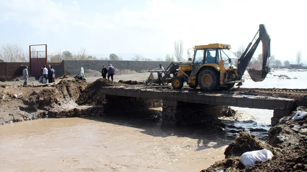 Trabajos para recomponer un puente desbordado por las aguas de un río debido a las inundaciones registradas en el norte de Irán, al sur de Tabriz.