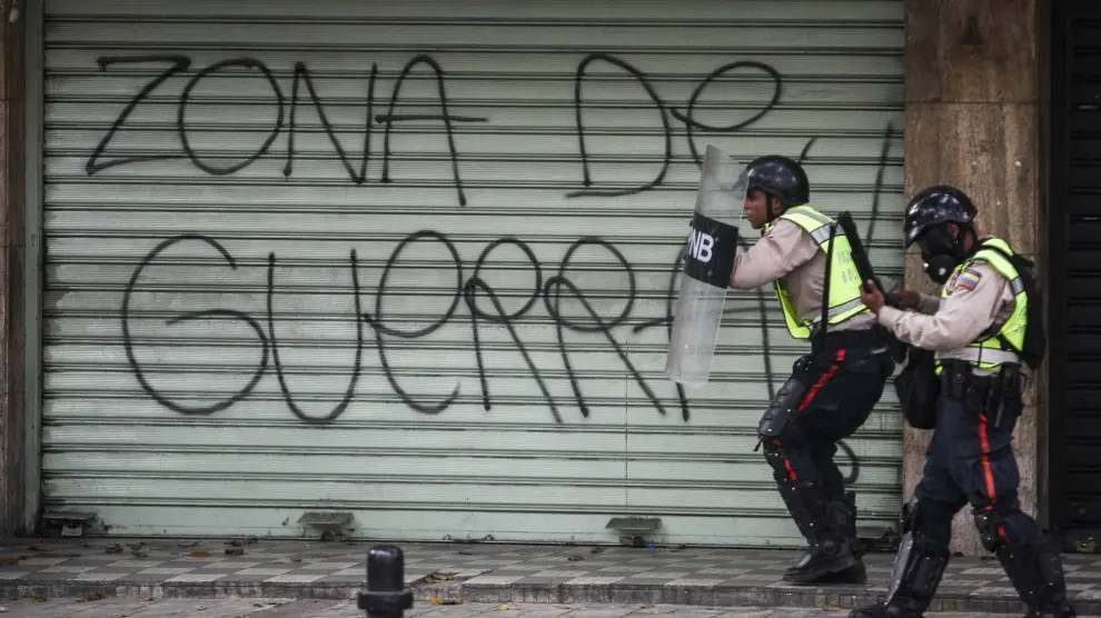 Agentes de la Policía Nacional Bolivariana bloquean el paso a una marcha opositora en Caracas.