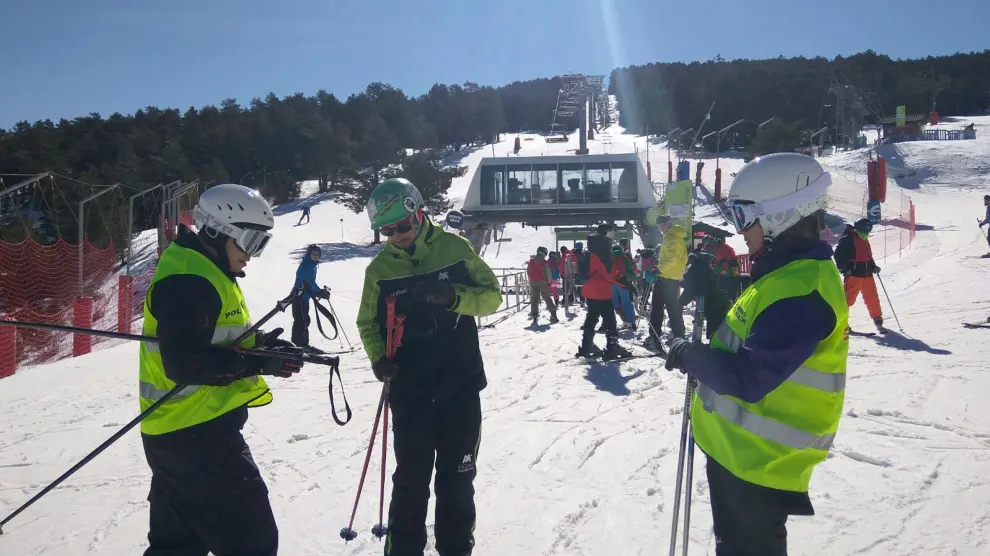 Dos agentes de la Unidad Adscrita solicitan la documentación a un monitor de esquí.