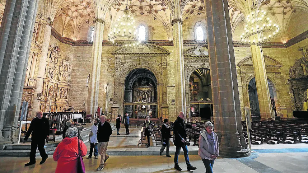 Un grupo de turistas visita la catedral y admira el sistema de claves y nervios que sustenta las bóvedas.