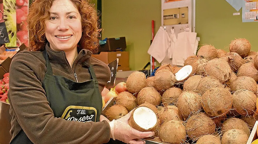 Isabel Andrés vende cocos en su puesto del Mercado Central de Zaragoza.