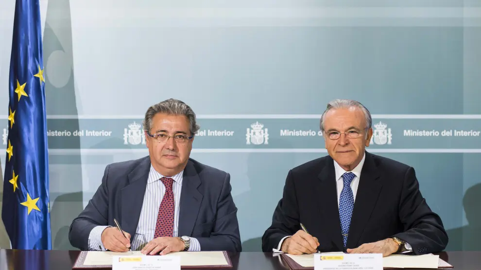 Juan Ignacio Zoido e Isidro Fainé firmando el nuevo acuerdo.