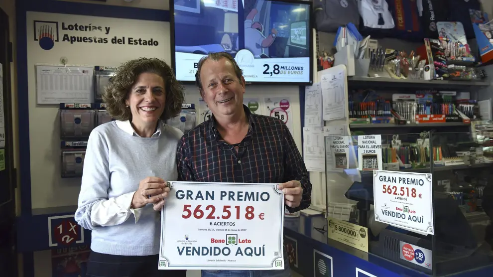 Pilar Lafarga y Luis Beired posan felices con el cartel que certifica el premio de la Bonoloto.