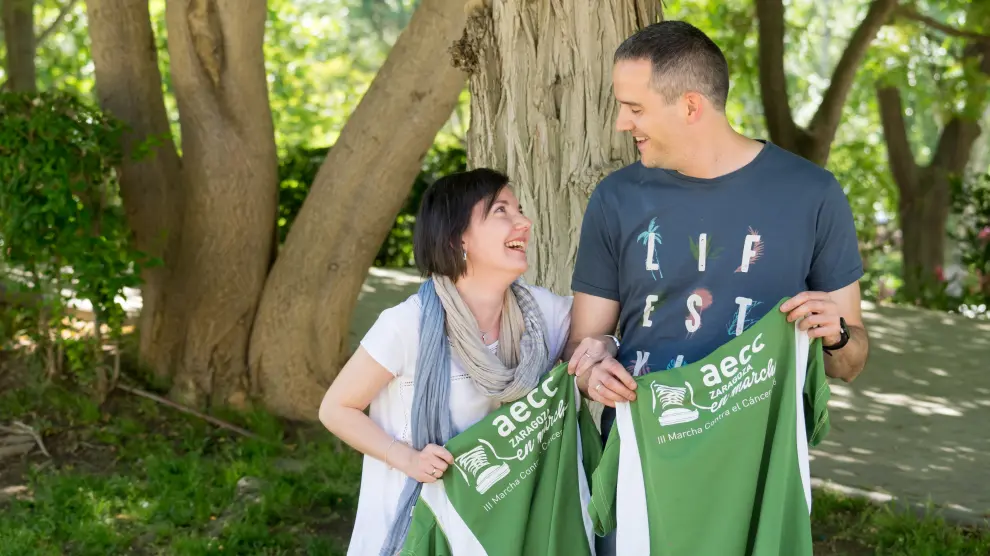Andrés López Blanco y su mujer, Myriam Bernal, con las camisetas de la Marcha contra el Cáncer en el parque Bruil de Zaragoza.