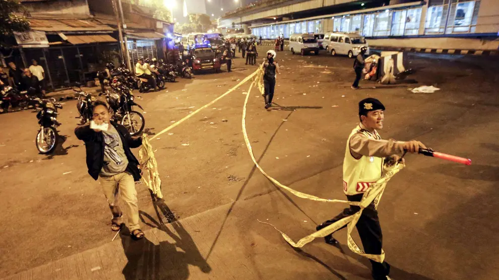 Policías indonesios acordonan la zona donde se han producido las explosiones, en la tarde de este miércoles en Yakarta.