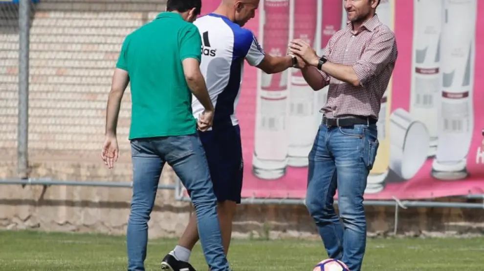 Lalo Arantegui, director deportivo del Real Zaragoza, saluda a un serio Láinez al inicio del entrenamiento de este lunes, en presencia de José Mari Barba, el secretario técnico.
