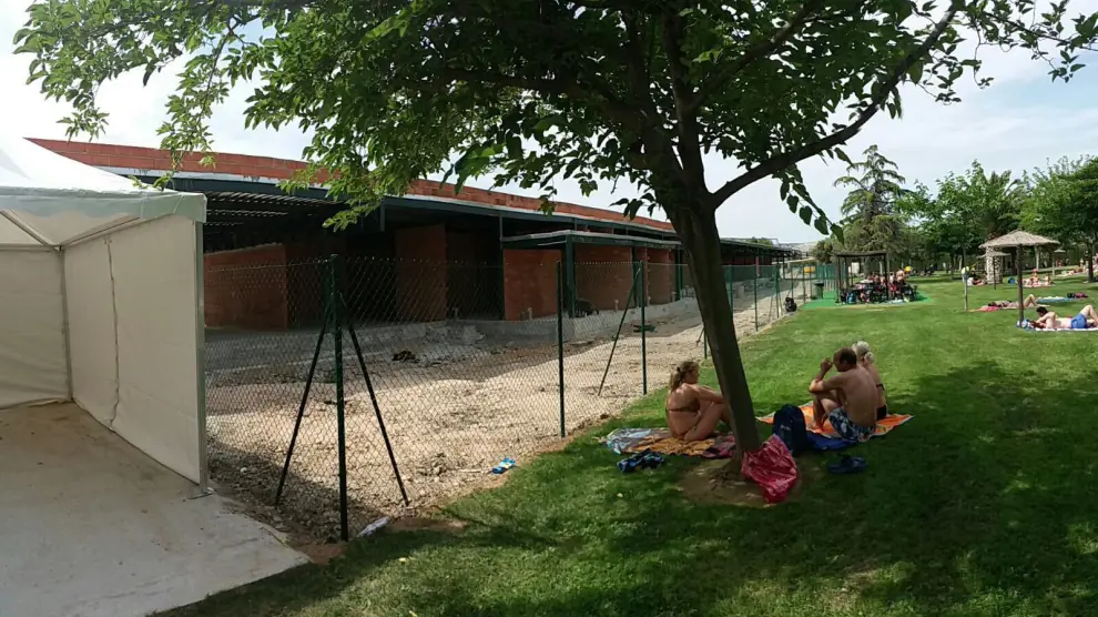 Una valla separa las piscinas de verano de las obras del pabellón de las Fuentes.
