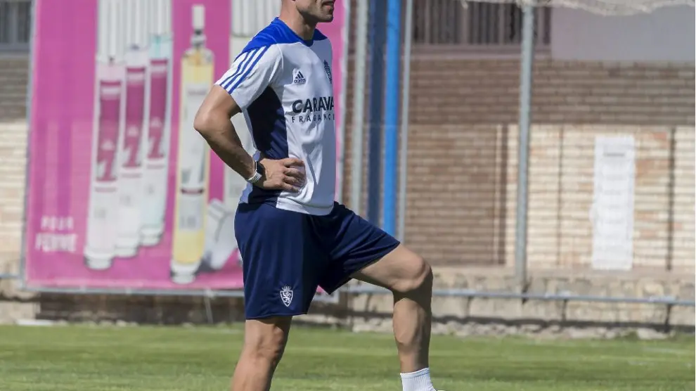 César Láinez, apoyado en un accesorio de goma, observa el inicio del entrenamiento del Real Zaragoza.