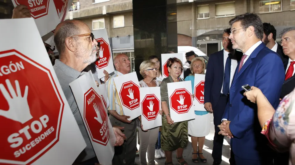 El ministro Catalá conversa con miembros de la plataforma Stop Sucesiones, este martes en Zaragoza.