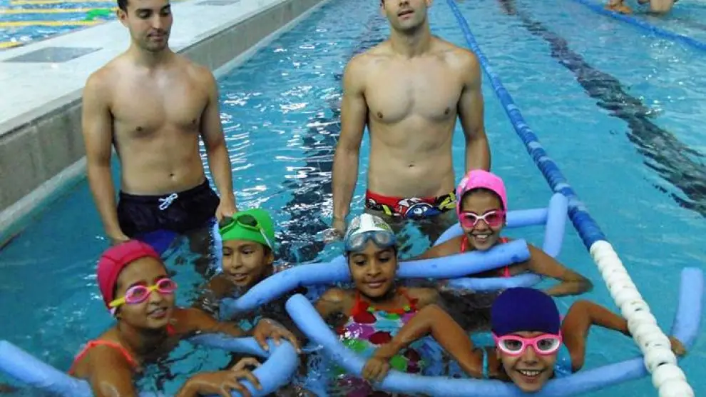 Enguia Mohamed-Nayem Did, la niña del centro, durante los cursillos de natación en el CN Helios.