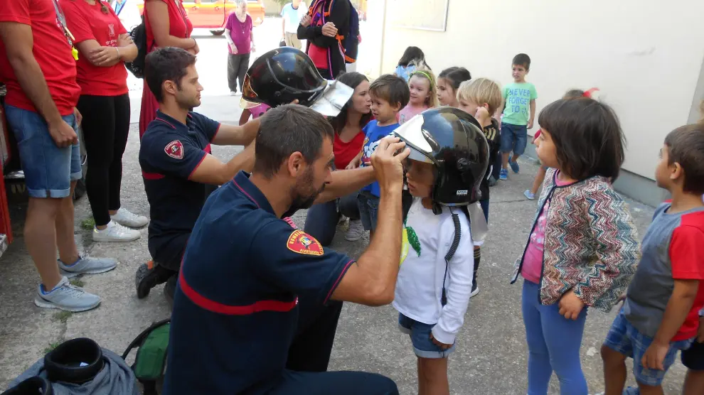 Los niños han podido probarse los cascos de los bomberos.