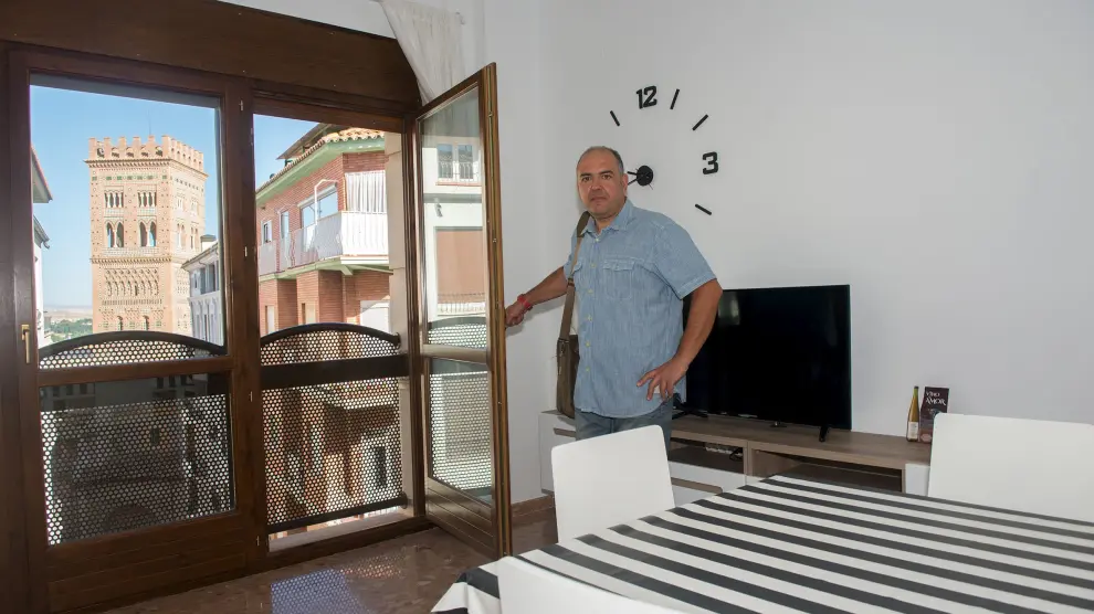 Rafael Sanz en su piso de Teruel, desde el que se ve la torre mudéjar del Salvador.