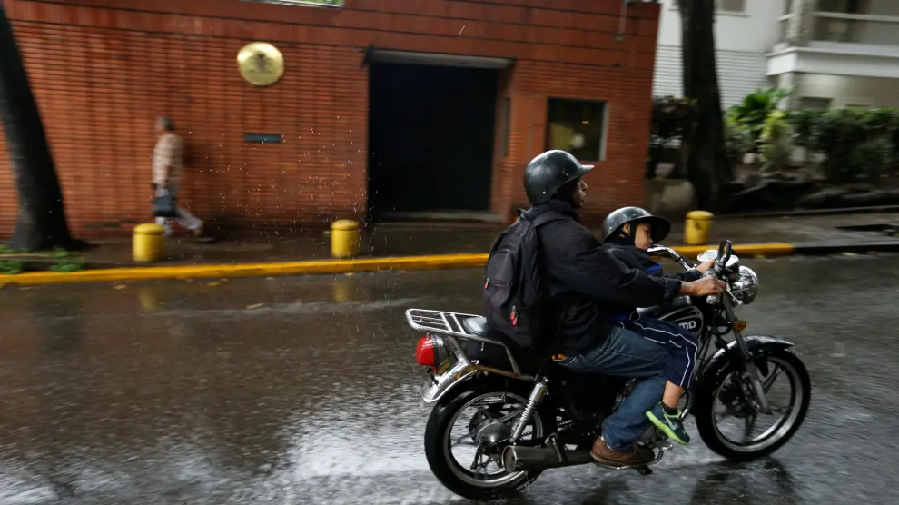 Una motocicleta circulando junto a la sede de la embajada española en Caracas