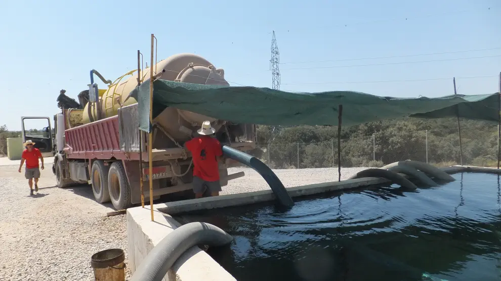 El camión cisterna de una empresa distribuidora carga agua en la balsa de los regantes de Sarrión.