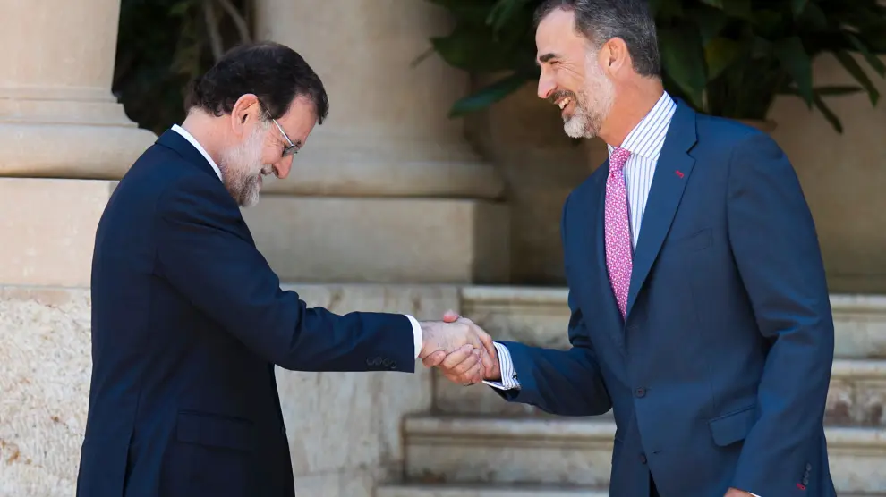 El Rey Felipe VI y el presidente del Gobierno, Mariano Rajoy, en la entrada del Palacio de Marivent,poco antes del tradicional despacho de verano.