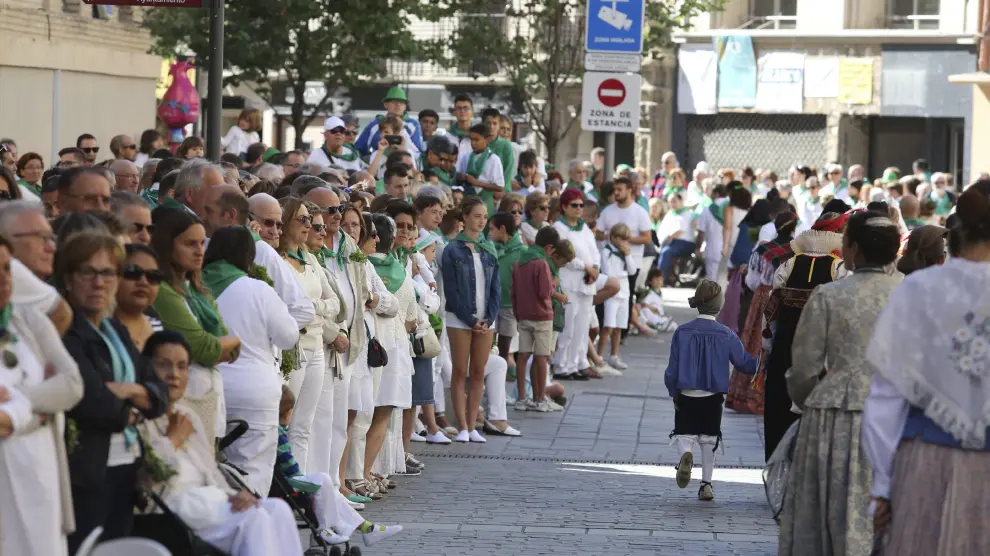 Espectadores contemplando el paso de la procesión en el Coso Alto, a la altura de Correos.