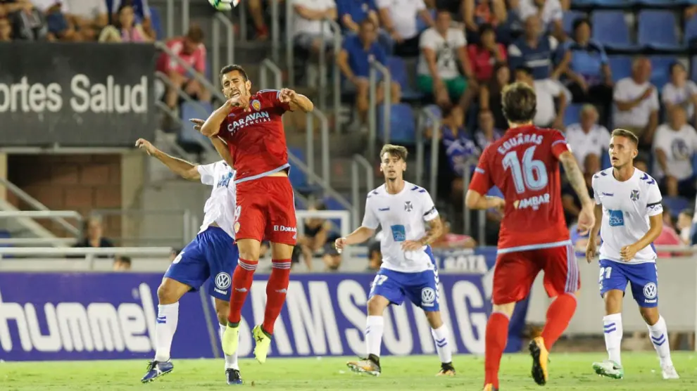 Borja Iglesias, salta con un rival en la disputa del balón, ante la mirada de Eguaras, en el primer partido de liga, el pasado viernes en Tenerife.